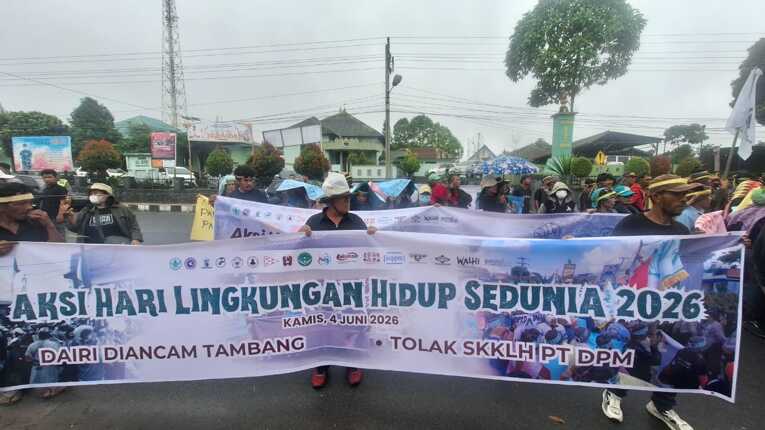 Masyarakat Dairi membentangkan spanduk penolakan izin kelayakan lingkungan PT DPM. Foto: Bakumsu
