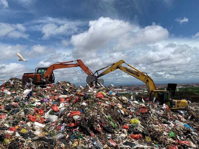 Tampak dua alat berat sedang beroperasi di atas tumpukan sampah di Bali. Sumber: AZWI.
