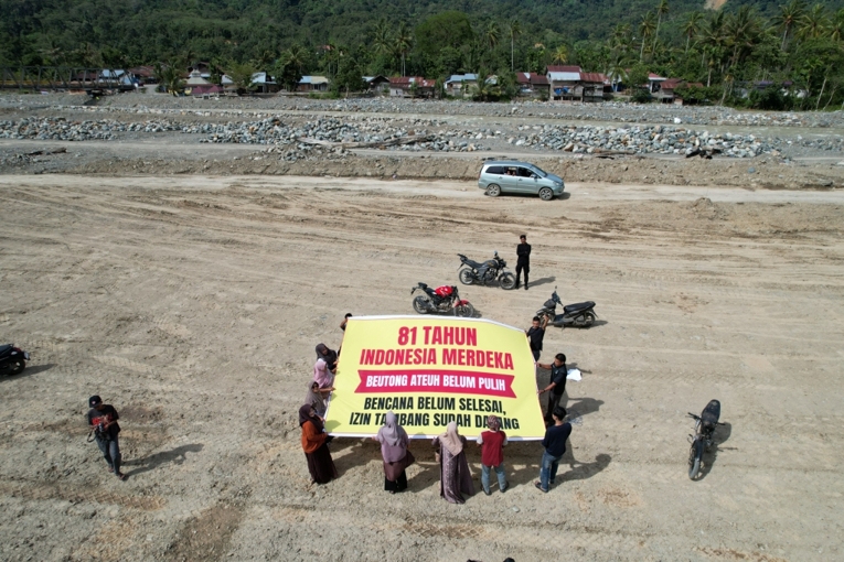 Warga Beutong Ateuh bersama aktivis lingkungan membentangkan spanduk di hari peringatan proklamasi kemerdekaan RI ke-81. Foto: Apel Green Aceh.