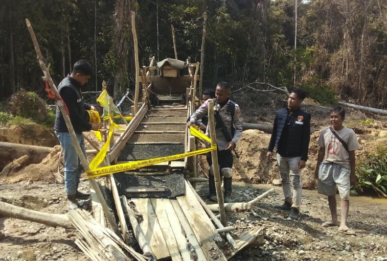 Aparat kepolisian memasang garis polisi di salah satu peralatan tambang di Desa Rantau Layung. Sumber: Jatam Kaltim.