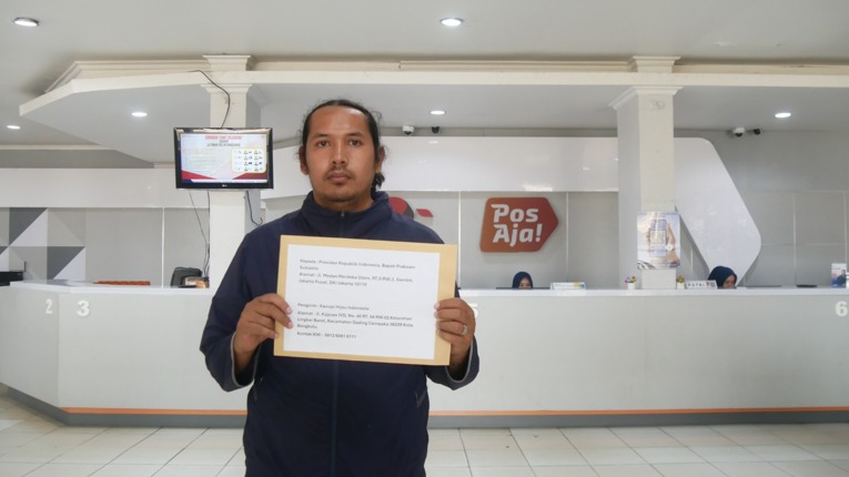 Cimbyo berfoto dengan surat keberatan yang akan dikirimkan kepada Presiden Prabowo, pada Rabu (14/10/2026). Sumber: Koalisi STuEB.