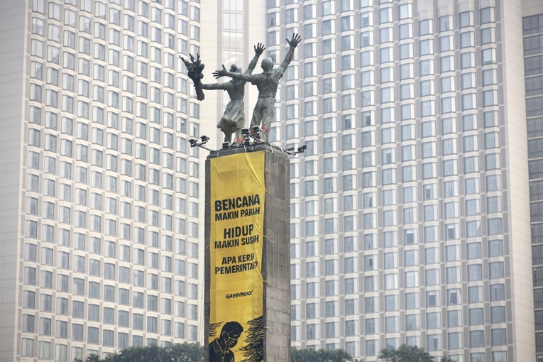 Aksi pembentangan dua spanduk raksasa di Bundaran HI, Jakarta, menuntut pemerintah serius tangani dampak krisis iklim. Sumber: Greenpeace Indonesia.