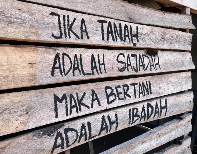 Kalimat penyemangat perjuangan petani Pakel yang dituliskan di dinding papan. Sumber: Tekad Garuda.