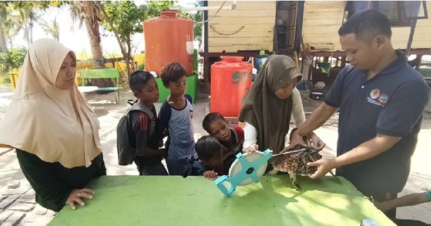 Bocah bernama Supran dan rekan-rekannya menyaksikan pengukuran penyu sisik oleh petugas Taman Nasional Taka Bonerate, yang ia serahkan. Penyu yang terjerat jaring ayahnya itu, lalu dilepasliarkan, 23 Juli 2020. (Dok.KSDAE/KLHK)
