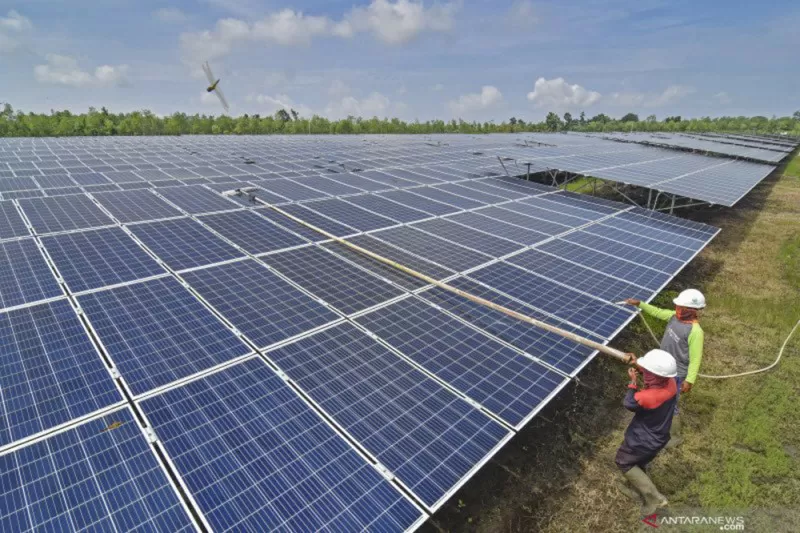 Pekerja membersihkan panel PLTS di Desa Sengkol Kecamatan Pujut, Lombok Tengah, NTB, Selasa (2/2/2021)./Foto: Antara (Ahmad Subaidi/wsj.)